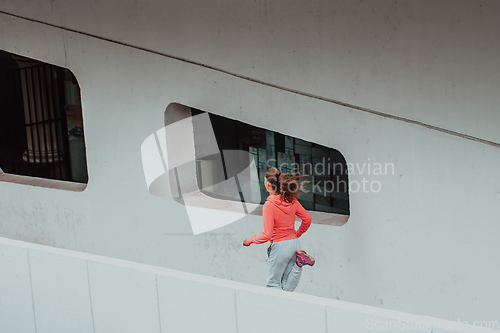 Image of Women in sports clothes running in a modern urban environment. The concept of a sporty and healthy lifestyle