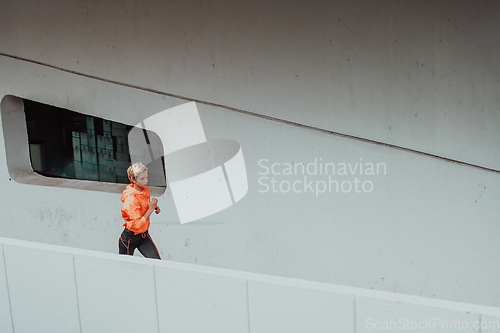 Image of Women in sports clothes running in a modern urban environment. The concept of a sporty and healthy lifestyle