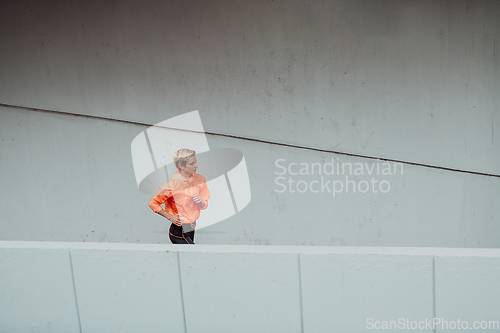 Image of Women in sports clothes running in a modern urban environment. The concept of a sporty and healthy lifestyle