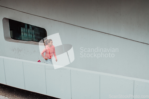 Image of Women in sports clothes running in a modern urban environment. The concept of a sporty and healthy lifestyle