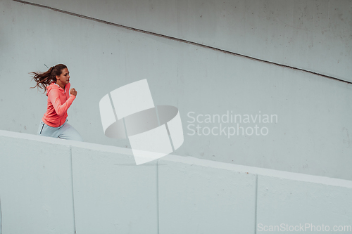 Image of Women in sports clothes running in a modern urban environment. The concept of a sporty and healthy lifestyle