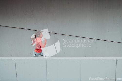 Image of Women in sports clothes running in a modern urban environment. The concept of a sporty and healthy lifestyle