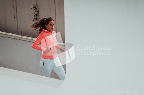 Image of Women in sports clothes running in a modern urban environment. The concept of a sporty and healthy lifestyle