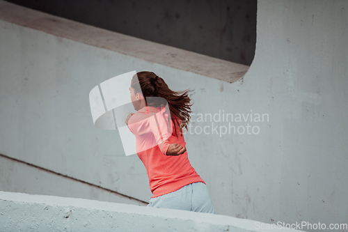 Image of Women in sports clothes running in a modern urban environment. The concept of a sporty and healthy lifestyle