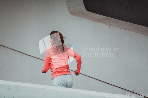 Image of Women in sports clothes running in a modern urban environment. The concept of a sporty and healthy lifestyle