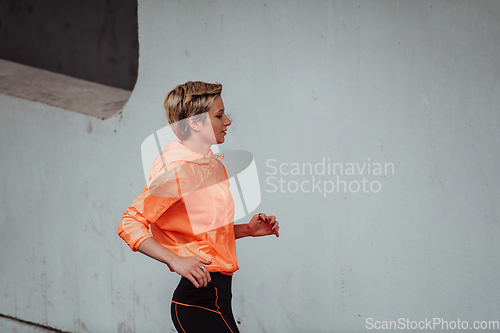 Image of Women in sports clothes running in a modern urban environment. The concept of a sporty and healthy lifestyle