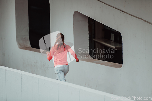 Image of Women in sports clothes running in a modern urban environment. The concept of a sporty and healthy lifestyle