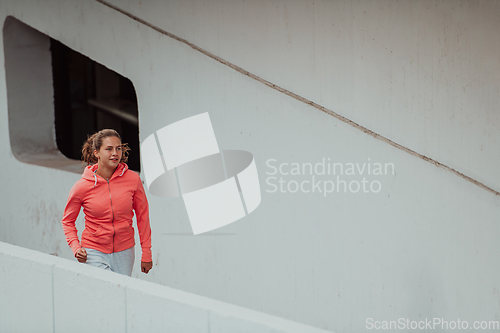 Image of Women in sports clothes running in a modern urban environment. The concept of a sporty and healthy lifestyle