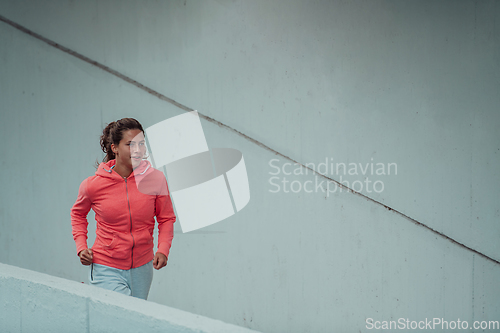 Image of Women in sports clothes running in a modern urban environment. The concept of a sporty and healthy lifestyle