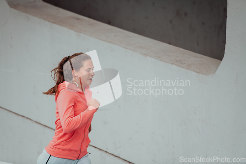 Image of Women in sports clothes running in a modern urban environment. The concept of a sporty and healthy lifestyle