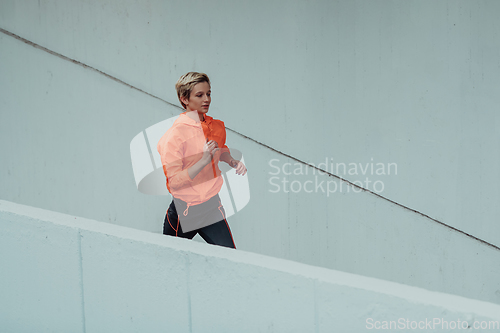 Image of Women in sports clothes running in a modern urban environment. The concept of a sporty and healthy lifestyle