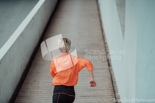 Image of Women in sports clothes running in a modern urban environment. The concept of a sporty and healthy lifestyle