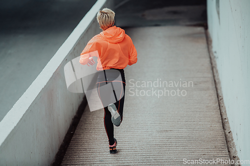 Image of Women in sports clothes running in a modern urban environment. The concept of a sporty and healthy lifestyle