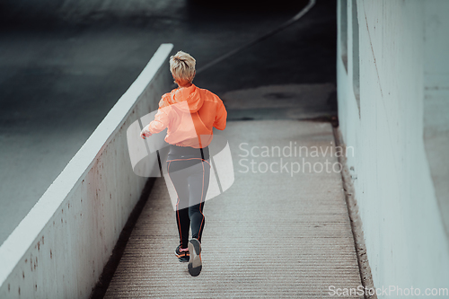 Image of Women in sports clothes running in a modern urban environment. The concept of a sporty and healthy lifestyle