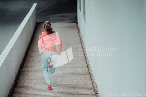 Image of Women in sports clothes running in a modern urban environment. The concept of a sporty and healthy lifestyle