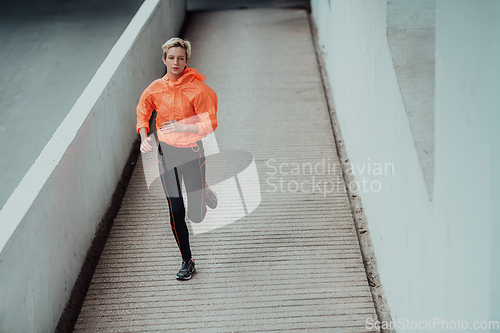 Image of Women in sports clothes running in a modern urban environment. The concept of a sporty and healthy lifestyle