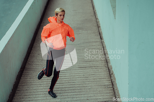 Image of Women in sports clothes running in a modern urban environment. The concept of a sporty and healthy lifestyle