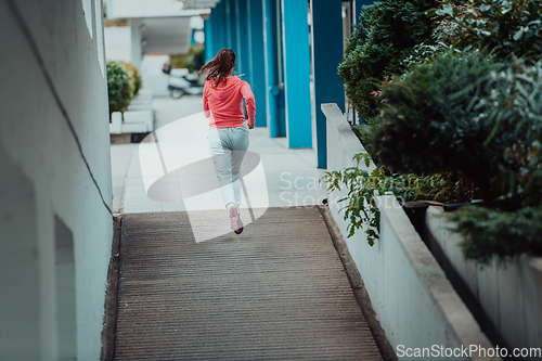 Image of Women in sports clothes running in a modern urban environment. The concept of a sporty and healthy lifestyle