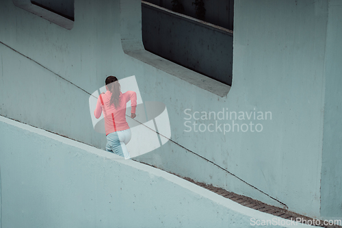 Image of Women in sports clothes running in a modern urban environment. The concept of a sporty and healthy lifestyle