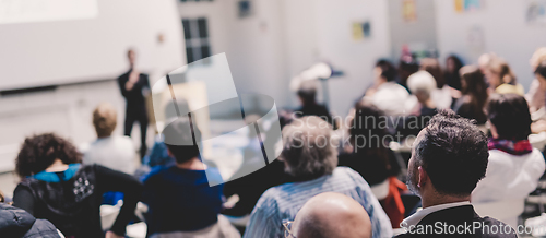 Image of Woman giving presentation in lecture hall at university.