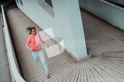 Image of Women in sports clothes running in a modern urban environment. The concept of a sporty and healthy lifestyle