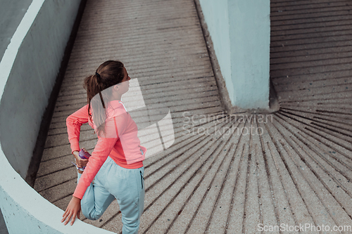 Image of Fit attractive woman in sportswear stretching before jogging. Workout, sport, activity, fitness, vacation and training concept.