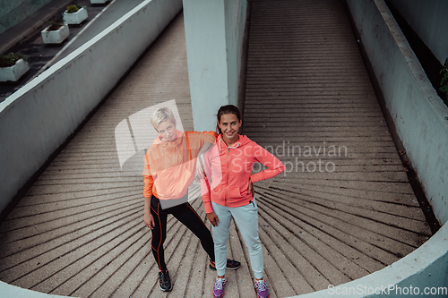 Image of Two lgbt woman resting after a hard training in an urban environment