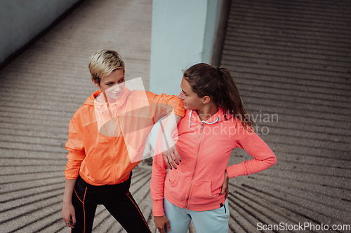 Image of Two lgbt woman resting after a hard training in an urban environment