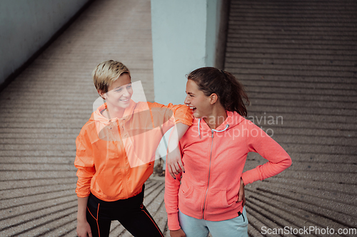 Image of Two lgbt woman resting after a hard training in an urban environment