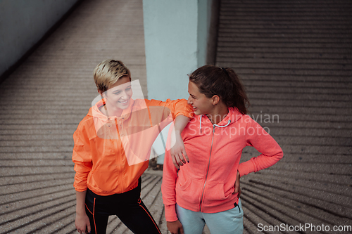 Image of Two lgbt woman resting after a hard training in an urban environment