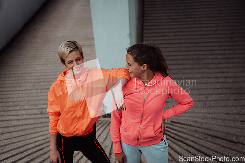 Image of Two lgbt woman resting after a hard training in an urban environment