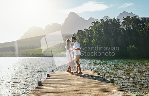 Image of Love, couple and dance at lake pier, smile or bonding outdoors on vacation at sunrise. Dancing date, having fun and happy man and woman on anniversary celebration for romantic holiday at summer creek