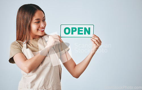 Image of Coffee shop, small business and woman holding an open sign in studio on a gray background for hospitality. Cafe, startup and management with a female entrepreneur indoor to display advertising