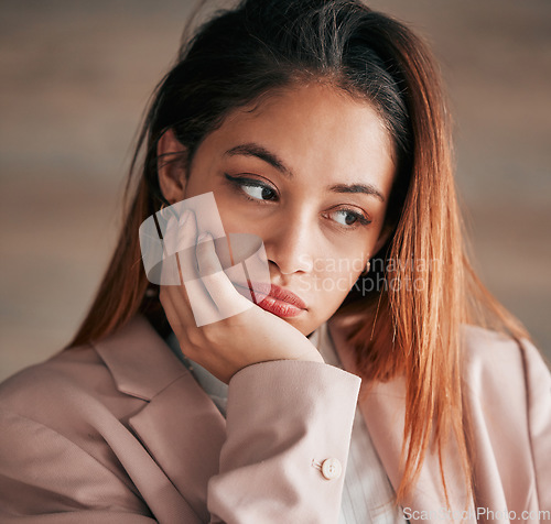 Image of Face, thinking and depression with a woman feeling or looking sad and alone on a blurred background. Mental health, down and lonely with an unhappy or miserable young female sitting hand on chin