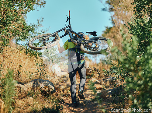 Image of Back, man and carrying bicycle in nature, walking and traveling outdoor in woods. Sports, fitness and male cyclist or athlete carry mountain bike for exercise, training or workout for transportation.