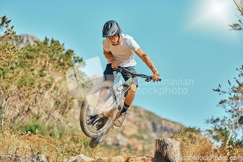 Image of Cycling, jumping and man on bicycle in the countryside for fitness, stunt and freedom on blue sky background. Nature, biking and guy cyclist training, practice and speed, action and free in Mexico