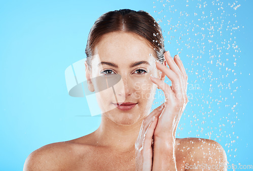 Image of Shower portrait, water and woman in a studio feeling happy from cleaning and skincare. Wellness, splash and beauty routine of a female model with dermatology and self care with blue background