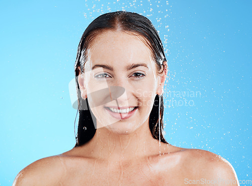 Image of Shower, water and portrait of a happy woman in a studio from cleaning and skincare. Wellness, cosmetics and beauty routine of a female model with dermatology and self care with blue background