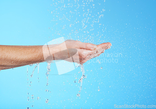 Image of Woman hands, cleaning and water in a studio for skincare, safety and healthcare from virus. Isolated, blue background and hand wash for hygiene wellness and sanitary protection with liquid stream