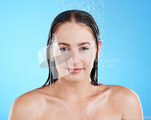 Image of Shower portrait, water and woman in a studio with a smile from cleaning and skincare. Wellness, bathroom and beauty routine of a female model relax from dermatology and self care with blue background