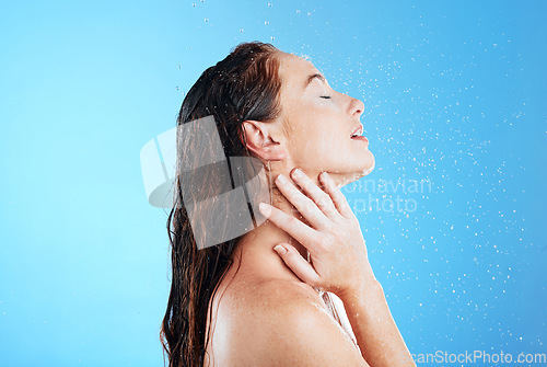 Image of Water, shower and washing profile of woman in studio for skincare, wellness and clean body for self care. Female aesthetic model, splash or drop for cleaning, hygiene and cosmetics on blue background