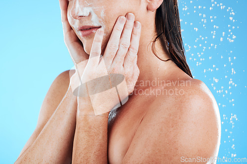 Image of Woman face cleaning, shower water and studio with a young female hands doing skincare. Bathroom, dermatology beauty and facial treatment of a model hand with mock up and isolated blue background