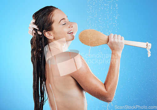 Image of Shower singing, skincare and woman smile with happiness karaoke in a studio. Bathroom, music and happy female model on isolated blue background and cleaning brush for beauty routine and wet wellness