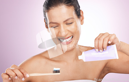 Image of Smile, woman and bamboo toothbrush and toothpaste in studio isolated on a purple background. Eco friendly, cleaning and happy mature female brushing teeth with natural wooden brush for dental hygiene