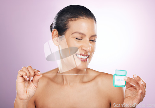 Image of Face, smile and woman with dental floss for cleaning, hygiene or tooth care in studio isolated on a purple background. Oral health, cosmetics and happy mature female model flossing teeth for wellness