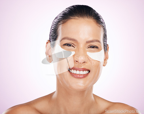 Image of Face, skincare and woman with eye patches in studio isolated on a purple background. Dermatology portrait, cosmetics and happy, mature and female smile with facial mask for collagen and anti aging.