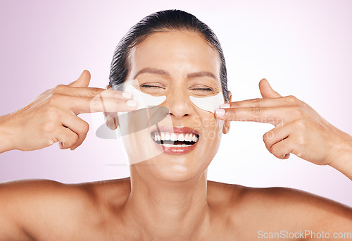 Image of Laughing, skincare and woman with eye patches in studio isolated on a purple background. Collagen cosmetics, dermatology and funny, smile and mature female model apply mask for healthy skin treatment