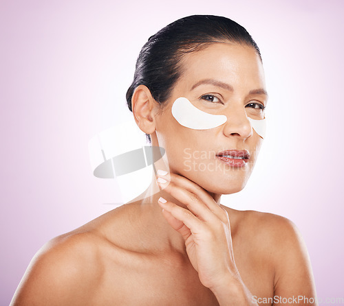 Image of Face, skincare and woman with eye patches in studio isolated on a purple background. Portrait, dermatology and serious or mature female model with facial mask or collagen cosmetics for healthy skin.
