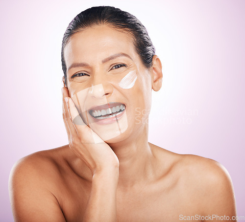 Image of Face, cream and skincare of woman laughing in studio isolated on a purple background. Mature, portrait and happy female model with dermatology lotion, creme and moisturizer cosmetics for anti aging.