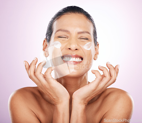 Image of Face smile, cream and skincare of woman in studio isolated on a purple background. Mature, beauty and happy female model with dermatology lotion, creme and moisturizer cosmetics for healthy skin.